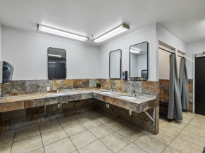 Remodeled restroom with stone counters and modern sinks